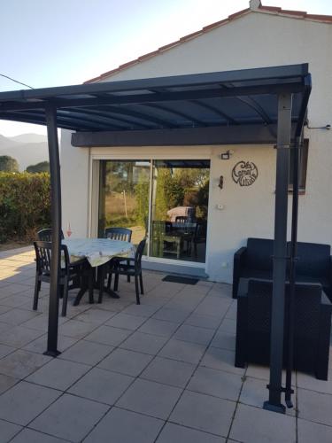 awning over a patio with a table and chairs at La Céret'nitude in Céret