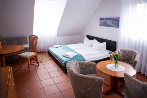 a room with a bed and a table and chairs at Hotel Sofra in Fürth