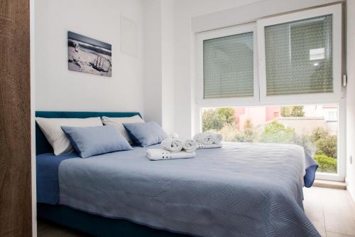 sypialnia z niebieskim łóżkiem i ręcznikami w obiekcie Apartment Mediteran w mieście Brodarica