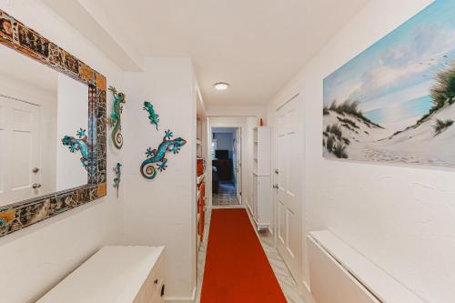 um corredor com paredes brancas e pinturas nas paredes em Captivating Cottage em Provincetown