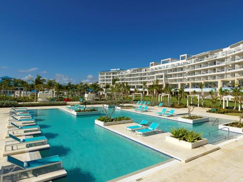 um resort com uma piscina com cadeiras e um edifício em Margaritaville Island Reserve Cap Cana Wave - An All-Inclusive Experience for All em Punta Cana