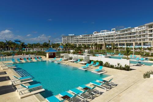 una gran piscina con sillas y un hotel en Margaritaville Island Reserve Cap Cana Wave - An All-Inclusive Experience for All, en Punta Cana