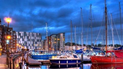 a group of boats docked in a harbor at night at Waterfront town centre ipswich apartment in Ipswich