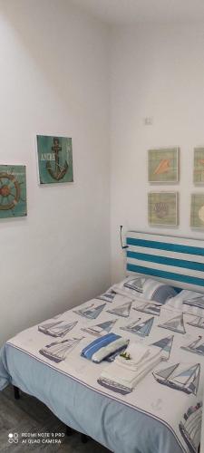 1 cama en un dormitorio con 2 cuadros en la pared en Appartamento Luelen en Alghero