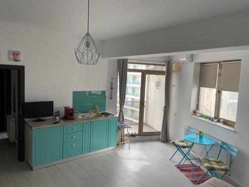 une cuisine avec un meuble bleu et une table dans l'établissement Azzurro Sea View Mamaia, à Mamaia