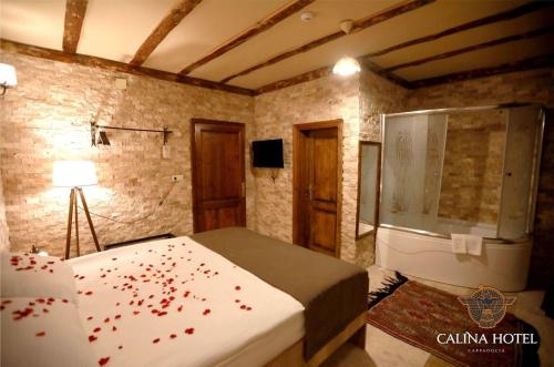 a bedroom with a bed and a shower with red hearts at Calina Hotel in Uçhisar