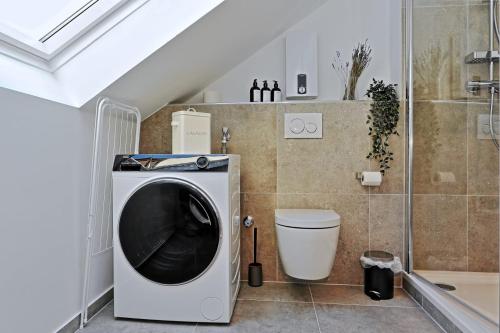 a washing machine and a toilet in a bathroom at Stylish 3BR apartment -10min to Hbf, full kitchen, homeoffice, Netflix, Wifi in Düsseldorf