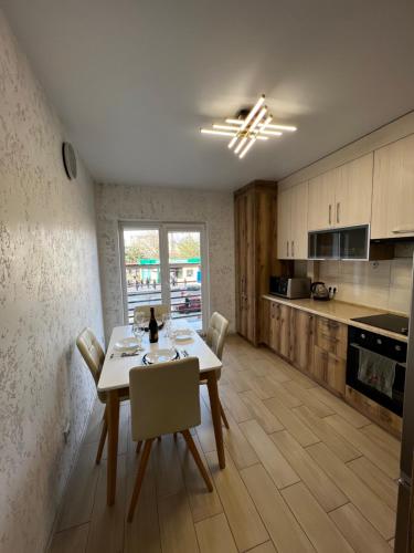 a kitchen and dining room with a table and chairs at New Apartment in Ivano-Frankivsʼk