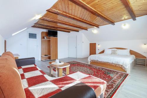 a bedroom with a bed and a couch and a rug at Casa Elia in Bran