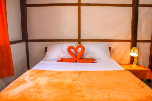 a bed with an orange ribbon on top of it at HANGA ROA HOTEL in Montañita