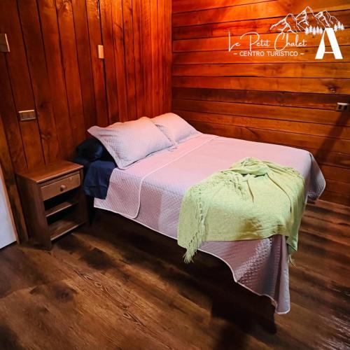 a bedroom with a bed and a wooden wall at Cabaña Sector La placeta, VII R. in El Torreón