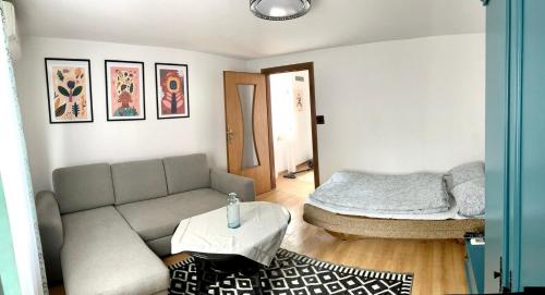 a living room with a couch and a bed at Słoneczny domek in Podzamcze