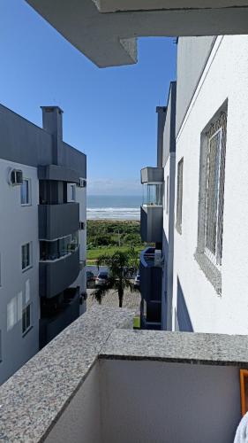 uma vista para o oceano a partir da varanda de um edifício em Condomínio Residencial Mar Azul em Imbituba