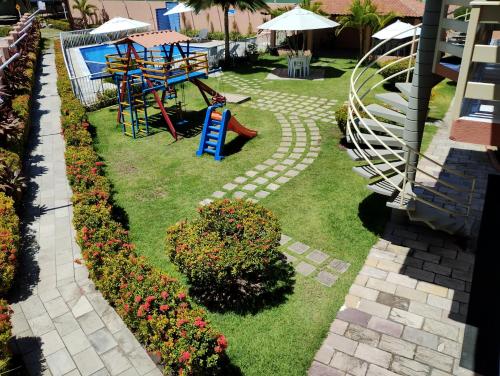 un jardín con parque infantil y un tobogán en Pousada Flats Recanto Sonhos do Porto, en Porto de Galinhas