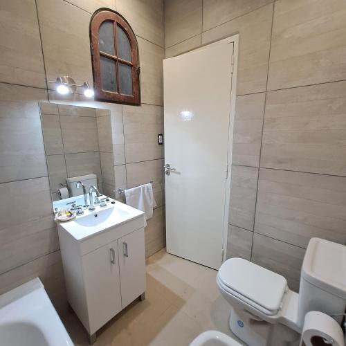 a bathroom with a sink and a toilet and a mirror at Down Town Telmo in Buenos Aires