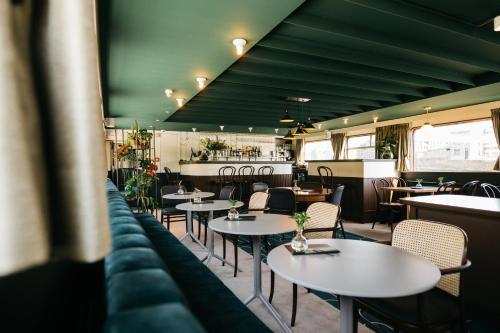 a restaurant with tables and chairs and a bar at Botel Maastricht in Maastricht