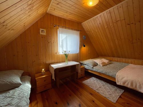 - une chambre avec 2 lits dans une cabane en bois dans l'établissement Domek Danusia z dwiema sypialniami, à Władysławowo