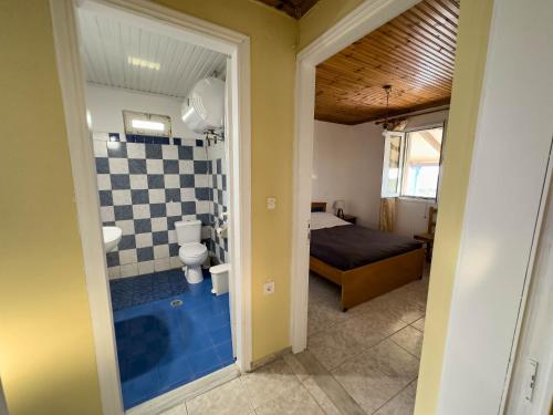 a bathroom with a toilet and a bed in a room at The Sea At Your Feet in Epitálion