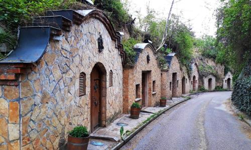 an alley with stone buildings on the side of a road at Négy Évszak Vendégház Nyúl in Nyúl