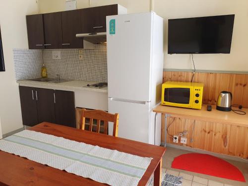a kitchen with a white refrigerator and a microwave at Motel E4 Kolmården Apartments And Cottages in Kolmården