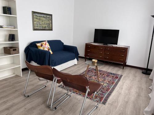 古岡佐拉的住宿－Buonarroti 37，客厅配有蓝色的沙发和电视