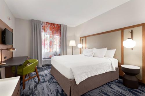 ein Hotelzimmer mit einem großen Bett und einem Schreibtisch in der Unterkunft Fairfield Inn by Marriott Visalia Sequoia in Visalia