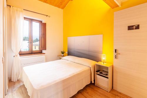 錫羅洛的住宿－Sirolo Sea rooms，卧室配有白色的床和黄色的墙壁