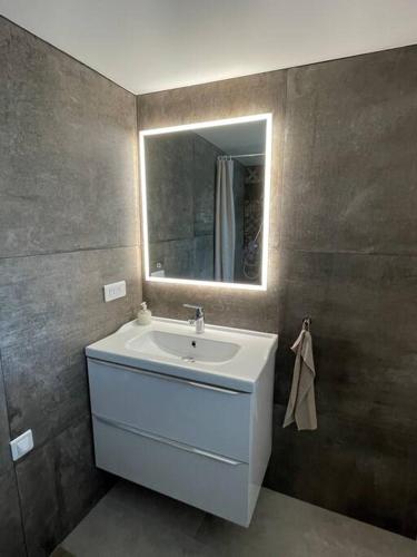 une salle de bain avec un lavabo et un miroir dans l'établissement Olivya, au Beausset