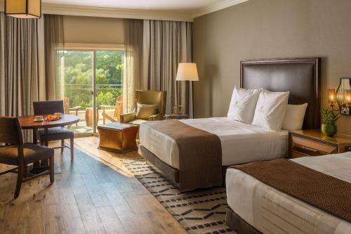 a hotel room with two beds and a desk and a table at La Cantera Resort & Spa in San Antonio
