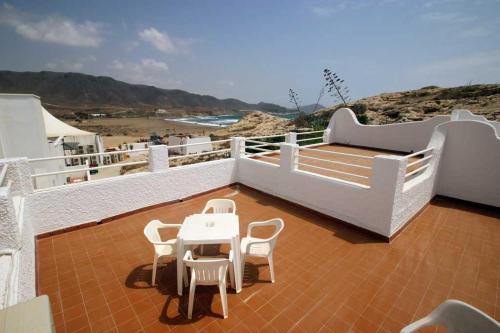 a balcony with a table and chairs and the beach at HOSTAL CASA EMILIO in Almería