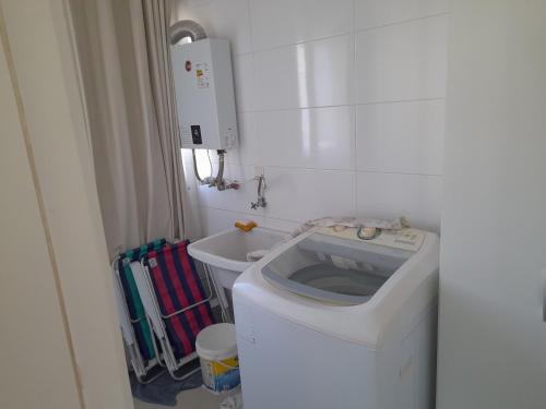 a small bathroom with a toilet and a sink at Confortável apartamento na praia in Capão da Canoa