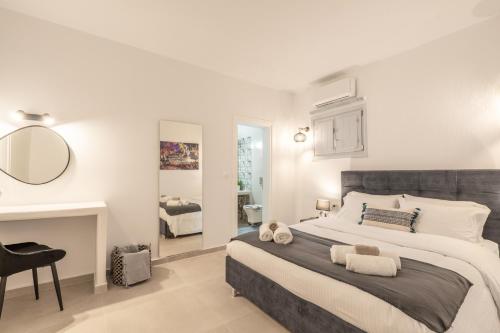 een slaapkamer met een groot bed en een spiegel bij SN Santorini Apartments in Kamari
