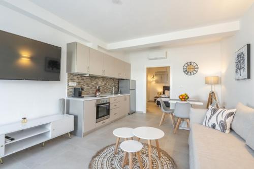 a kitchen and living room with a couch and a table at SN Santorini Apartments in Kamari