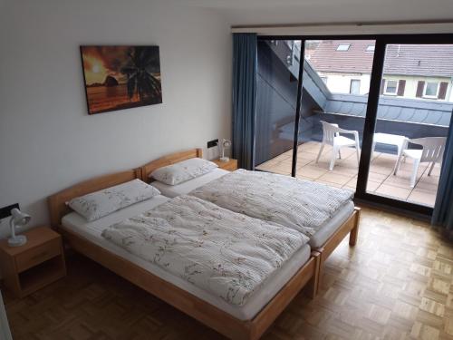 a bedroom with a bed and a balcony at ZumLeroy in Völklingen