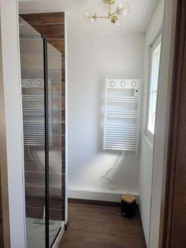 a glass shower in a room with a window at Mon ciel étoilé in Berck-sur-Mer