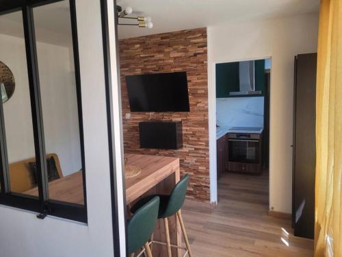 un salon avec une télévision, une table et des chaises dans l'établissement Mon ciel étoilé, à Berck-sur-Mer