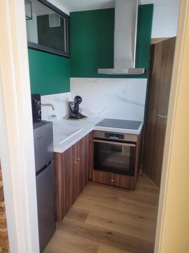 a small kitchen with a sink and a stove at Mon ciel étoilé in Berck-sur-Mer