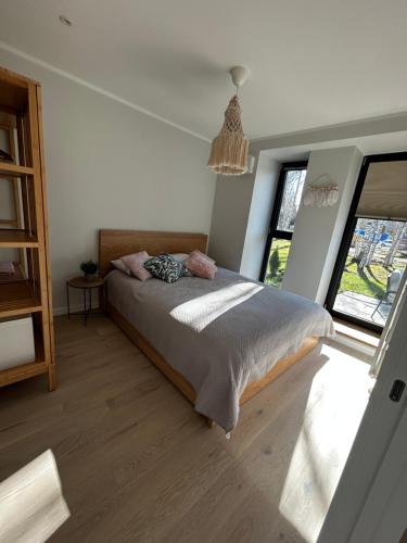 a bedroom with a bed in a room with windows at Albatross Getaway by the sea, SPA and forest with a Terrace in Ķesterciems
