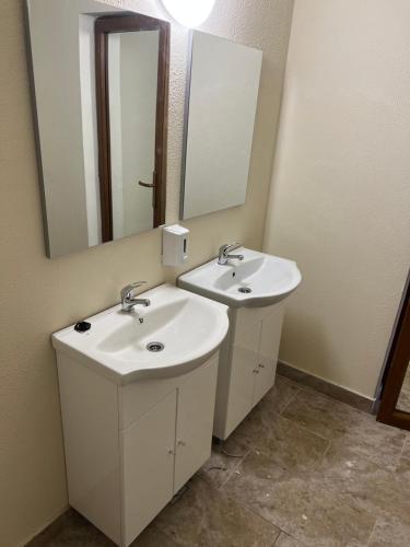 a bathroom with two sinks and a mirror at Hellen Residence in Costinesti