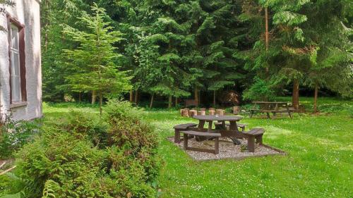 a picnic table and benches in a park at Chalupa Bonanza in Jívka