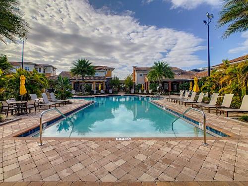 a swimming pool with chairs and a resort at Your Dream Apartment Stay in Kissimmee