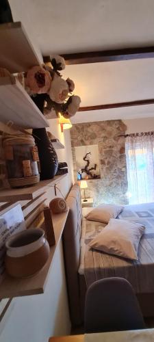 ein Schlafzimmer mit einem Bett und einer Steinmauer in der Unterkunft Apartments Rogoznička Oaza in Rogoznica