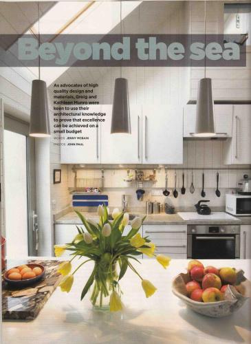 a kitchen with a bowl of fruit on a table at Driftwood Cottage, Findhorn Village in Forres