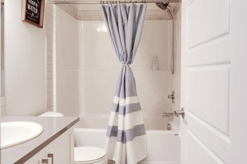 a bathroom with a toilet and a shower curtain at Condo in Southeast Calgary in Calgary