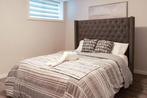 a bedroom with a bed with a blanket and pillows at Condo in Southeast Calgary in Calgary