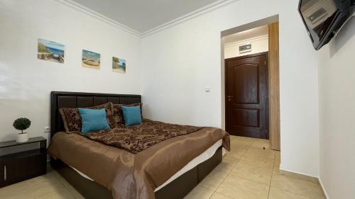 a bedroom with a large bed with blue pillows at FREGATA 16 Studio Sveti Vlas in Sveti Vlas