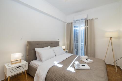 a white bedroom with a bed and a window at Corfu City Apartments in Corfu Town