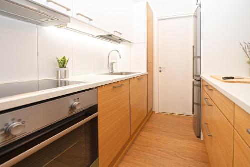 a kitchen with wooden cabinets and a sink at Kuopio in the City in Kuopio