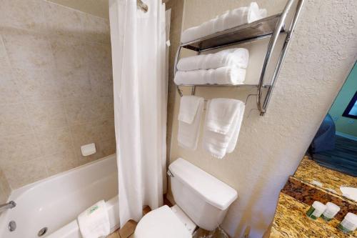 La salle de bains est pourvue de toilettes, d'une baignoire et de serviettes. dans l'établissement 301 - Surf Beach Resort, à St. Pete Beach