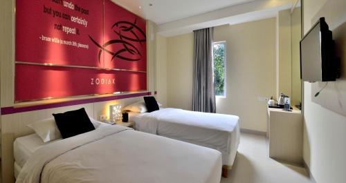 Tempat tidur dalam kamar di Zodiak Kebon Kawung by KAGUM Hotels